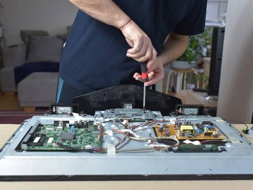 The man repairing broken tv at home